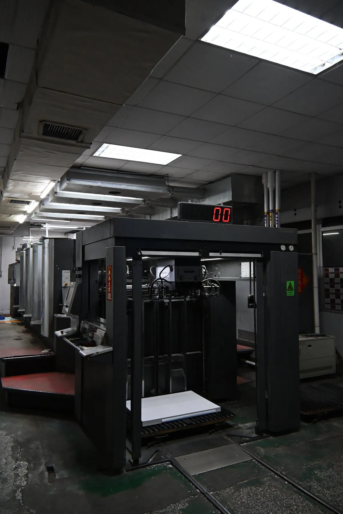 QicaiPress operators working beside a Heidelberg printing press